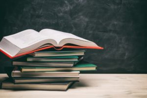 Books stacks on blackboard background